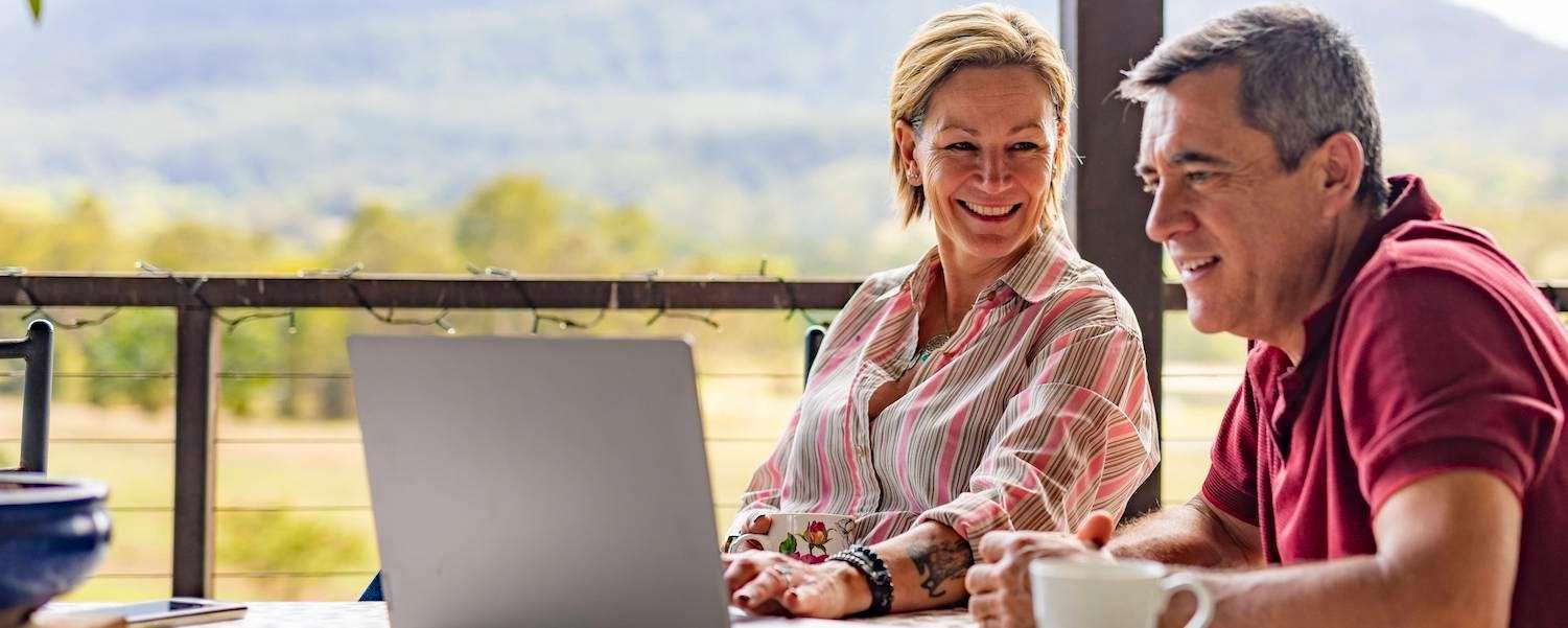 couple smiling while working on a computer